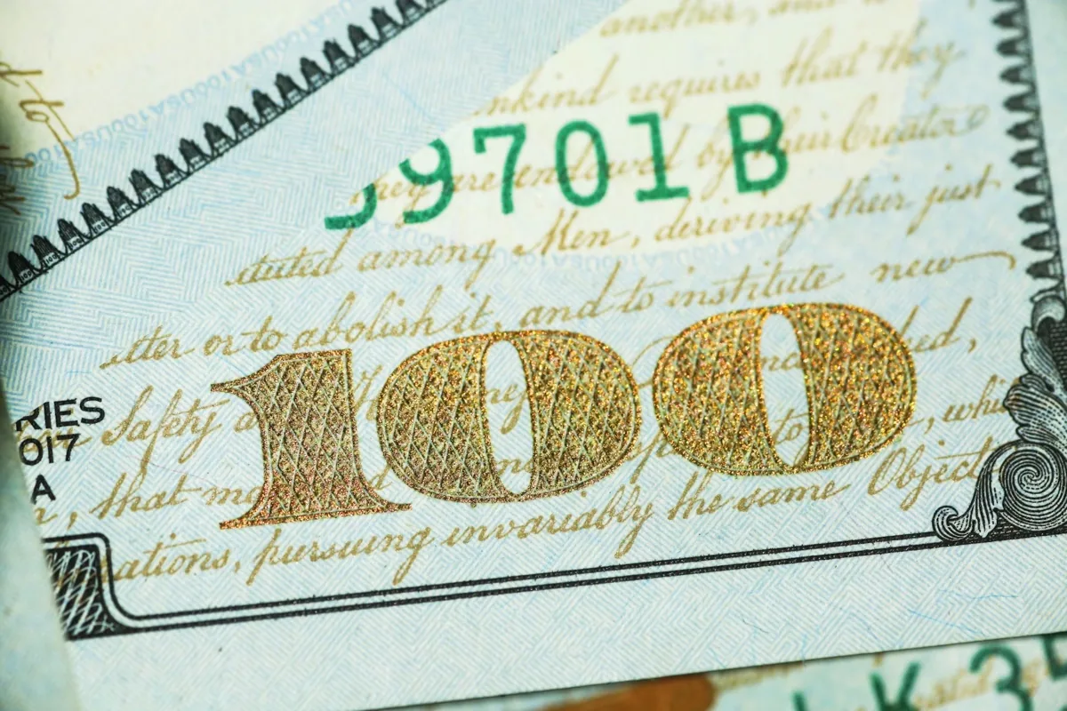 미국 100달러 지폐의 금박 숫자 100과 독립선언문 활자를 확대한 사진